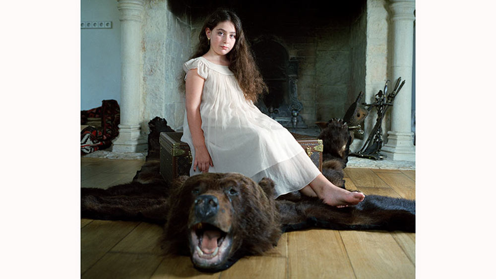 Girl sitting on a bear rug.