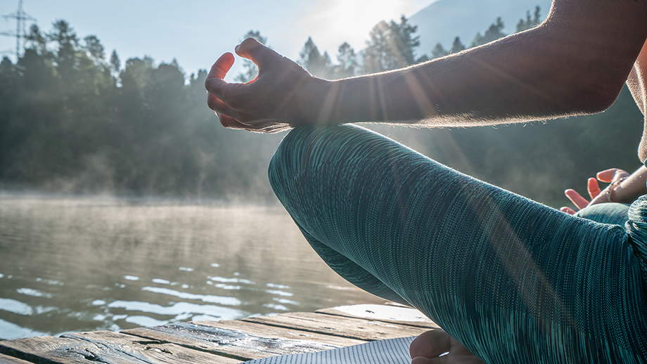 Meditierende Person am Wasser