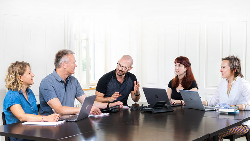 The five open access specialists sitting at a table.