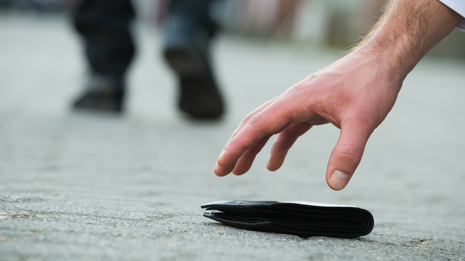 Hand, die nach Portemonnaie greift