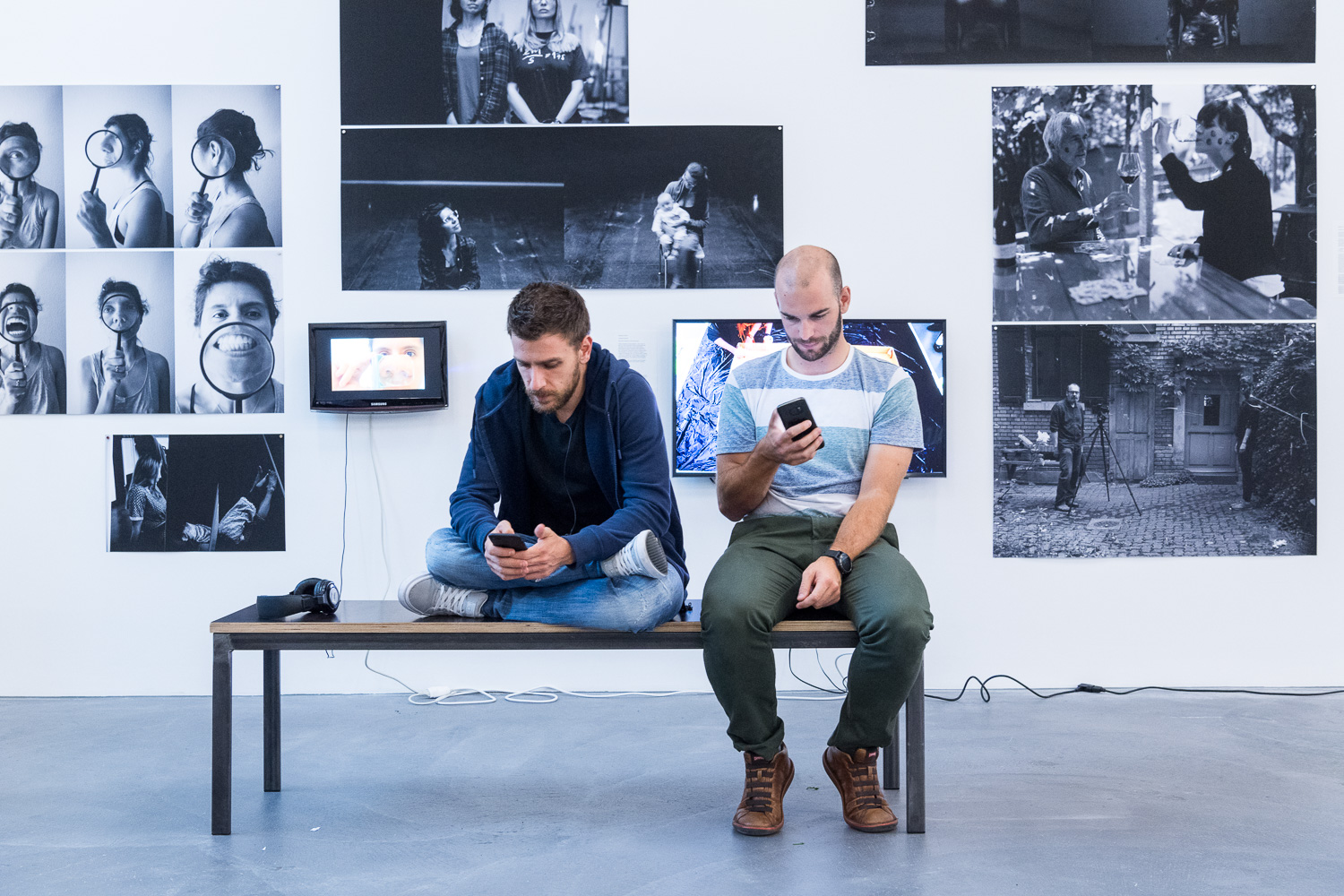 Konzentration vor dem Auftritt: Doktorand Davide Falanga und Ingenieur Julien Kohler, aufgenommen kurz vor ihrer Drohnenshow. Die Fotos im Hintergrund entstanden im Rahmen eines Seminars, das der polnische Aktionskünstler Artur Zmijewski zusammen mit UZH-Doktorierenden im Rahmen des Wissenschaftsfestivals durchführte.